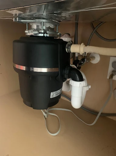 Garbage disposal unit installed under kitchen sink by Kabam Plumbing Services