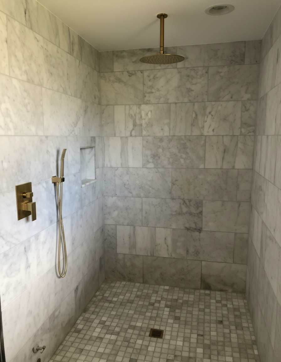 Luxury walk-in shower with rain showerhead and gold hardware installed by Kabam Plumbing