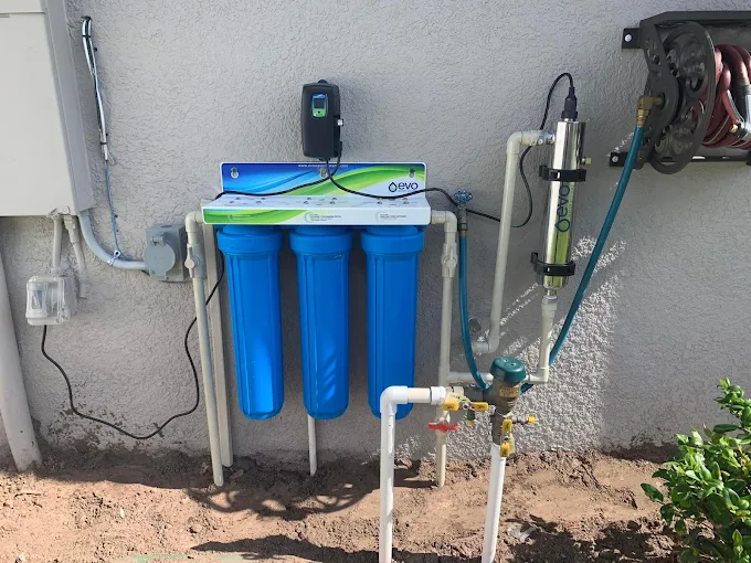 EVO whole-house water filtration system with three blue filter canisters